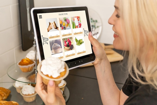 Mujer comprando comida en línea usando una tableta digital en la cocina, vista de cerca en la pantalla de una tableta. Concepto de comprar en línea usando dispositivos móviles.