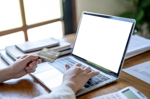 Mujer comprando en una computadora portátil con tarjeta de crédito para compras de comercio electrónico en línea de Internet gastando dinero Compras en línea Concepto de tecnología de computadora portátil de teléfono móvil