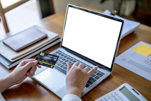 Foto mujer comprando en una computadora portátil con tarjeta de crédito para internet compras en línea de comercio electrónico gastar dinero compras en línea concepto de tecnología de teléfonos móviles portátiles