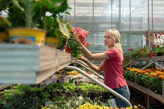 Mujer comprando flores de colores en el centro de jardinería