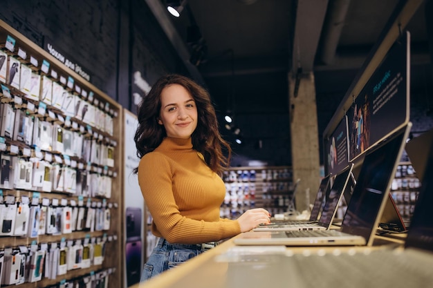 Mujer comprando una laptop en una tienda de tecnología