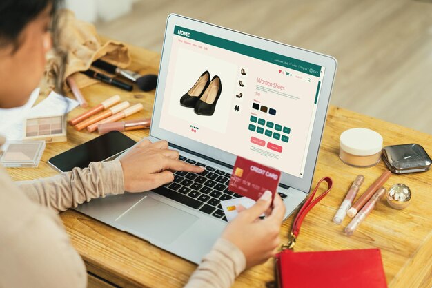 Mujer comprando en línea en el mercado de Internet buscando artículos en venta para un estilo de vida moderno y usando tarjeta de crédito para pagos en línea desde una billetera protegida por un software crucial de seguridad cibernética