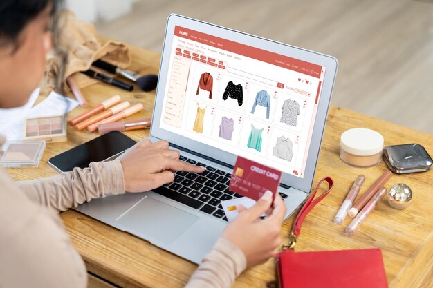 Mujer comprando en línea en el mercado de Internet buscando artículos en venta para un estilo de vida moderno y usando tarjeta de crédito para pagos en línea desde una billetera protegida por un software crucial de seguridad cibernética