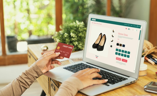 Mujer comprando en línea en el mercado de Internet buscando artículos en venta para un estilo de vida moderno y usando tarjeta de crédito para pagos en línea desde una billetera protegida por un software crucial de seguridad cibernética