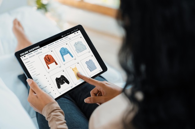 Mujer comprando en línea en el mercado de Internet navegando por artículos de venta cruciales