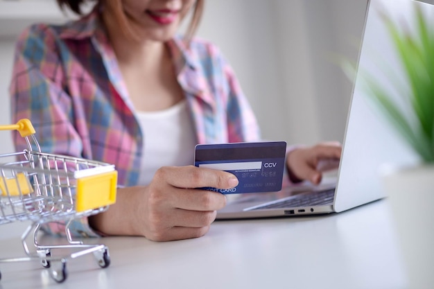 Mujer comprando en línea pagando con tarjeta de crédito La conveniencia de gastar sin efectivo se mantiene segura comprando desde casa y distancia social