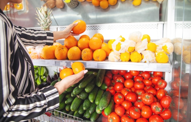 Mujer comprando mandarina en tienda de alimentos