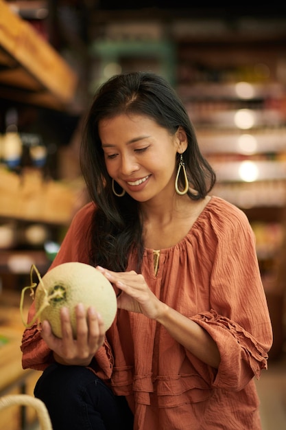 Mujer comprando melón fresco