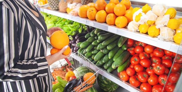 Mujer comprando naranja en la tienda de alimentos