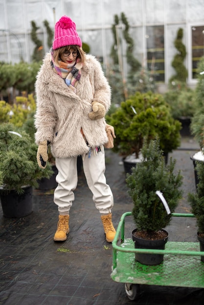 Mujer comprando plantas en el mercado al aire libre durante el invierno