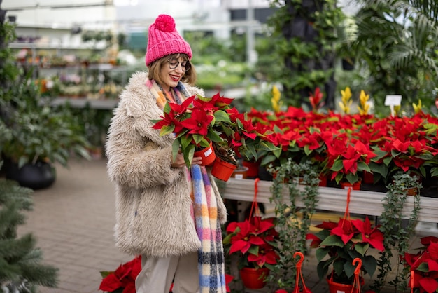 Mujer comprando plantas en el mercado al aire libre durante el invierno