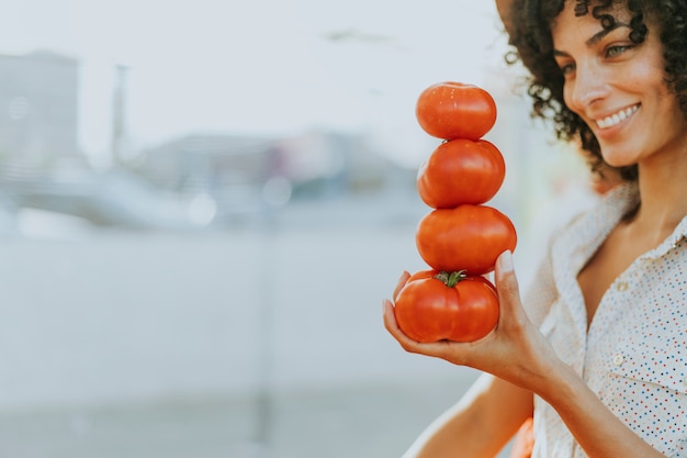 Mujer comprando tomates en un mercado de agricultores