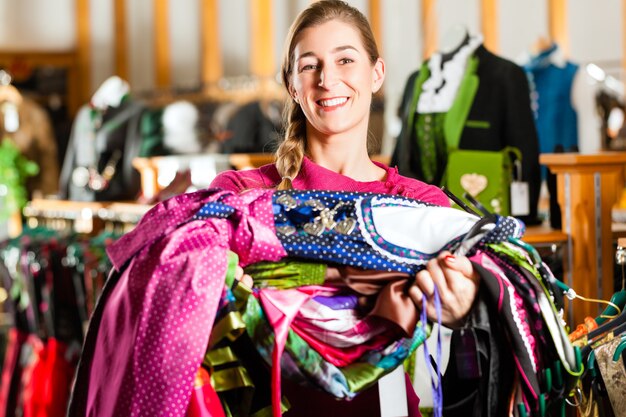 Foto mujer está comprando tracht o dirndl en una tienda.