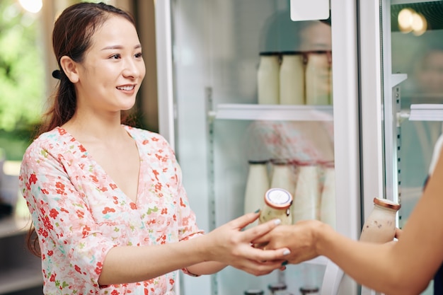 Mujer comprando yogur orgánico fresco