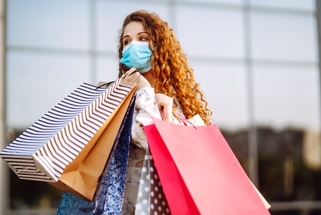 Mujer de compras. Chica joven en máscara médica protectora estéril en su rostro.