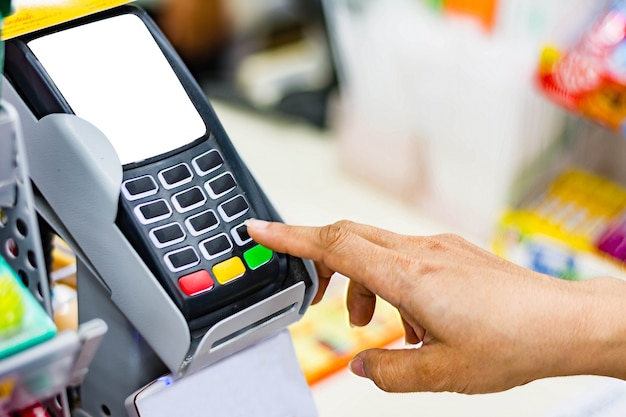 mujer de compras en conveniencia y entrar en un pin de seguridad en la terminal