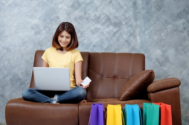 Foto mujer de compras en línea. sosteniendo la tarjeta de crédito en blanco.