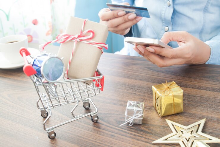 Foto mujer de compras en línea por tarjeta de crédito y teléfono móvil, centrarse en el carrito de la compra con caja de regalo