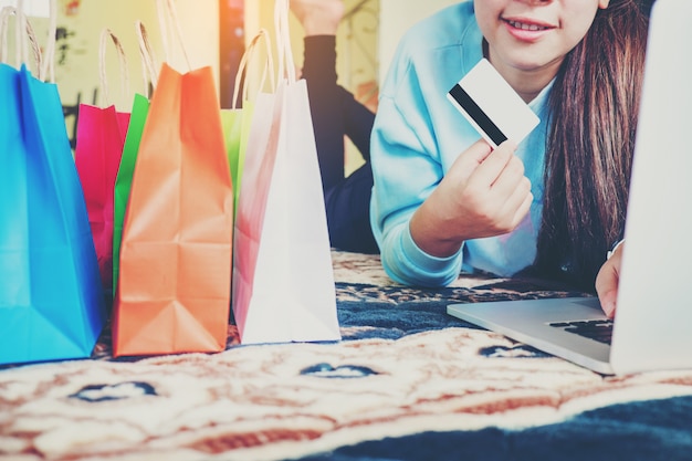 Foto mujer de compras en línea con teléfono inteligente con tarjeta de crédito disfrutando en casa