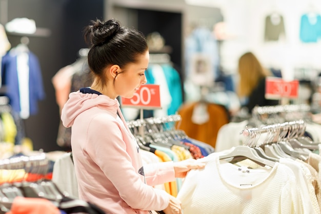 Mujer de compras en un mercado de vestidos