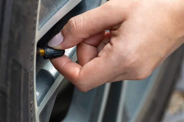 Mujer comprobando la calibración de los neumáticos del coche. mantenimiento del coche