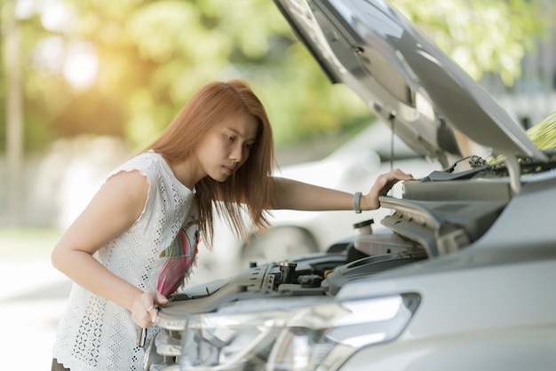 mujer comprobando el nivel de aceite en un automóvil, cambie el automóvil de aceite