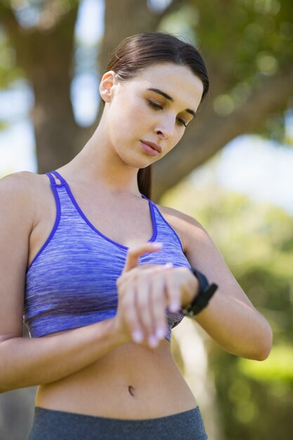 Foto mujer comprobando el tiempo mientras hace ejercicio