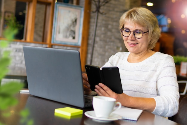 Una mujer con una computadora portátil está trabajando en una oficina.