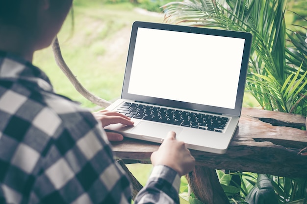 Mujer con la computadora portátil de la pantalla en blanco en la tabla en cafetería con la vendimia entonada.