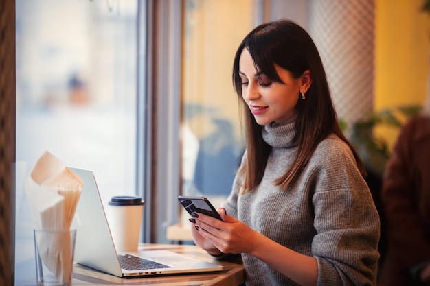 mujer con computadora portátil y teléfono móvil