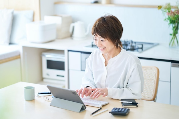 Mujer comunicándose en línea en la cocina comedor