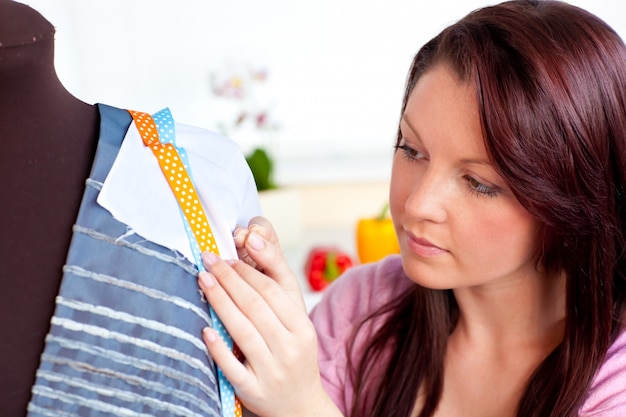 Mujer concentrada cosiendo en casa