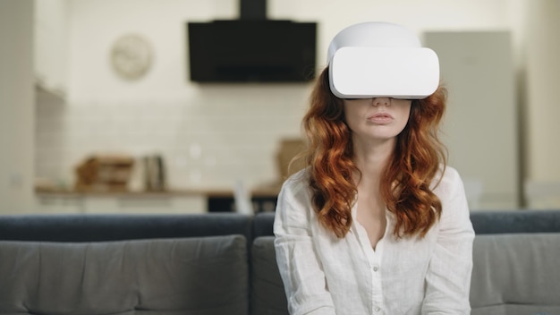 Mujer concentrada jugando al juego virtual en la cocina abierta
