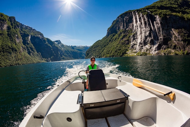 Mujer conduciendo un bote a motor. Fiordo de Geiranger, hermosa naturaleza Noruega.Vacaciones de verano.