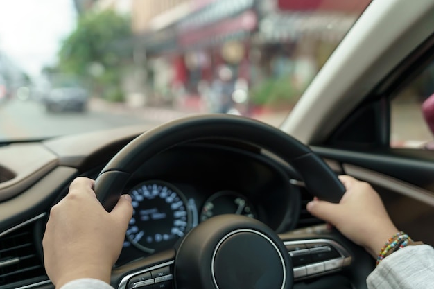 Mujer conduciendo un coche chica sintiéndose feliz de conducir sosteniendo el volante y mirando a la carretera