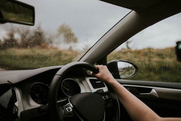 Mujer conduciendo un coche con la mano en el volante