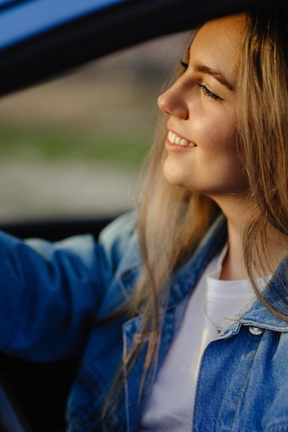 Una mujer conduciendo un coche con los ojos cerrados.