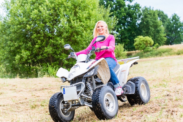 Mujer conduciendo fuera de la carretera con quad o ATV