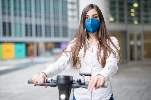 Mujer conduciendo un scooter eléctrico en una ciudad moderna