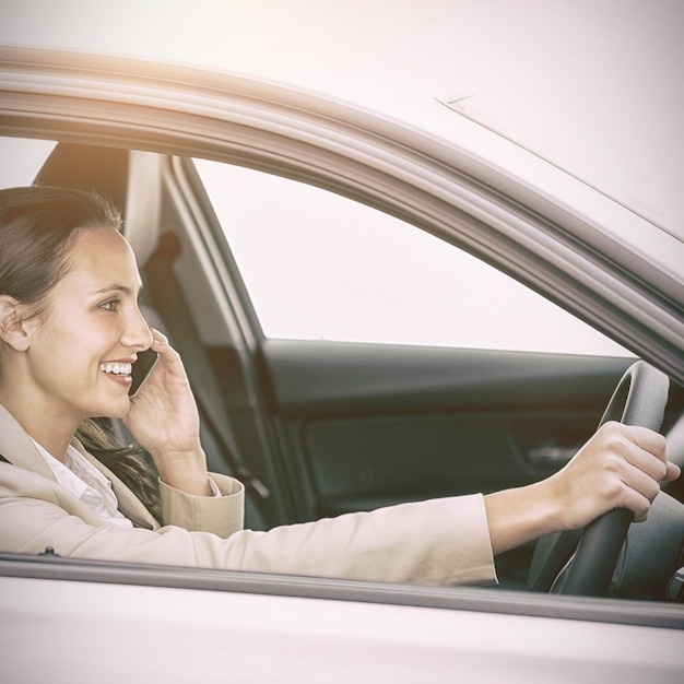 Foto mujer conduciendo y usando su teléfono inteligente