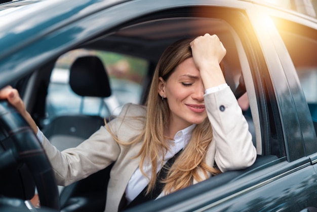 Mujer conductora asustada sorprendida antes de un accidente o un accidente con las manos al volante en la carretera