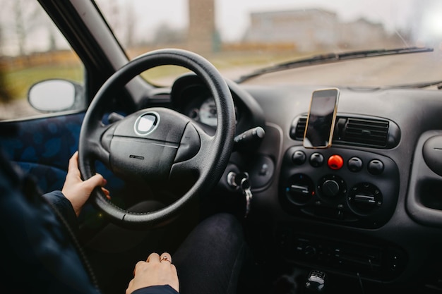 Mujer conductora de coche con las manos en el volante