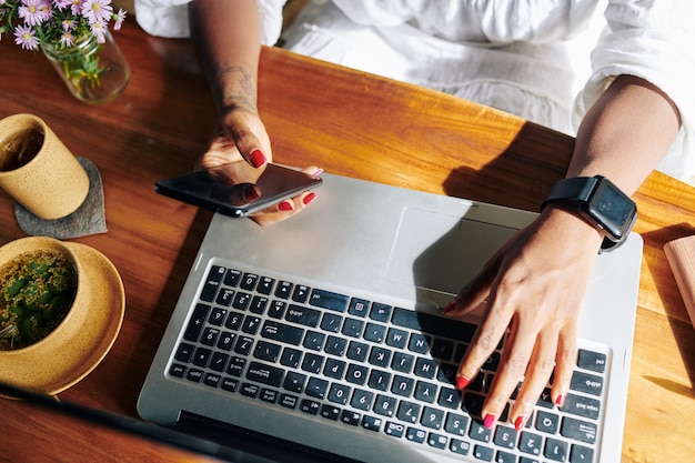 Mujer conectando teléfono con portátil