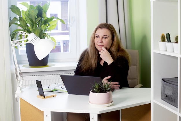 Foto mujer confiada de mediana edad que trabaja desde casa en un retrato de negocios femenino en cuarentena con una computadora portátil