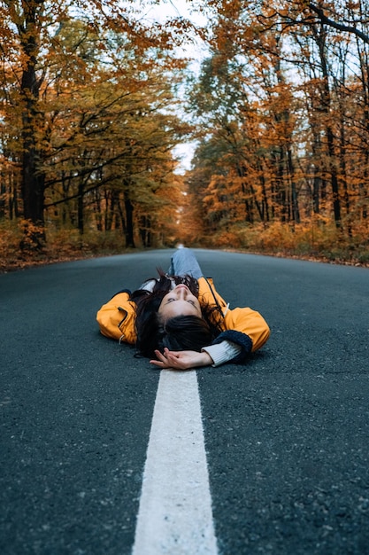 Foto mujer de confianza tirada en el camino con un árbol de otoño alrededor de una nueva dirección de ambición de elección de camino de vida