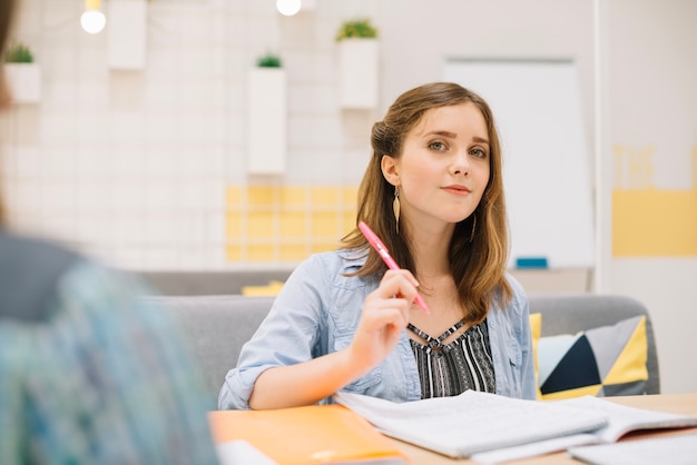 Mujer confidente que se sienta con los libros