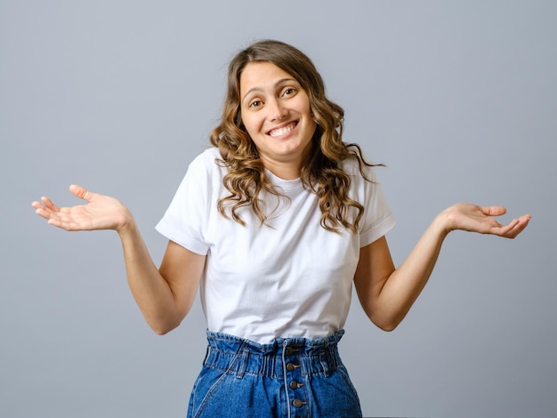 Mujer confundida extiende las manos hacia los lados