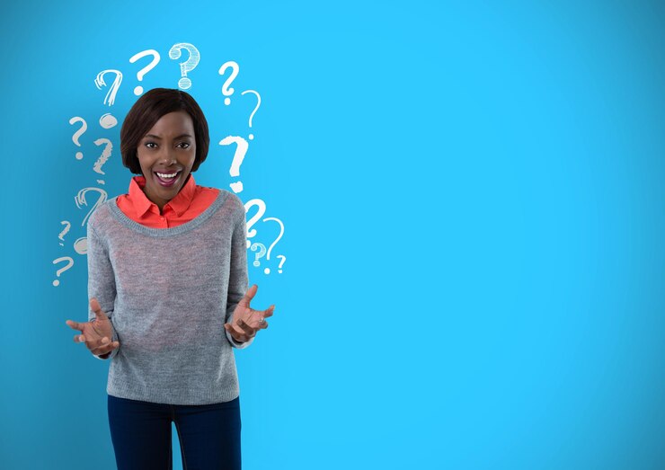 Foto mujer confundida o sorprendida con signos de interrogación sobre fondo azul.