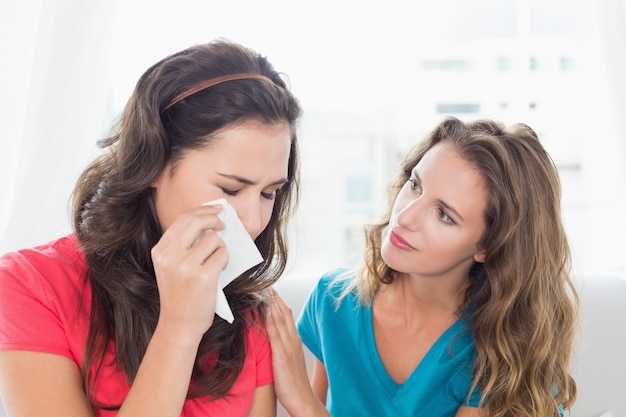 Mujer consolando a una amiga llorando en casa