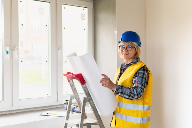 Mujer constructora en la habitación de la casa haciendo reparaciones